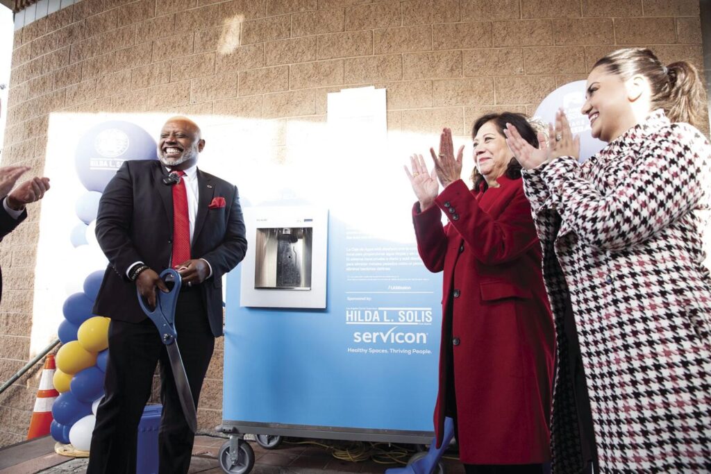 LA Mission President Troy Vaughn and LA County Supervisor Hilda L. Solis cut the ribbon for the new water box at the LA Mission. The box will provide clean water for the residents of Skid Row. - Photo by Chris Mortenson